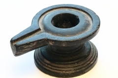 A BLACK CIRCULAR STONE YONI ON A MOULDED FOOT