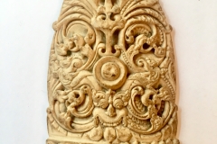 A bone curved plaque , carved with a Kurtimurka and leafy scrolling foliage