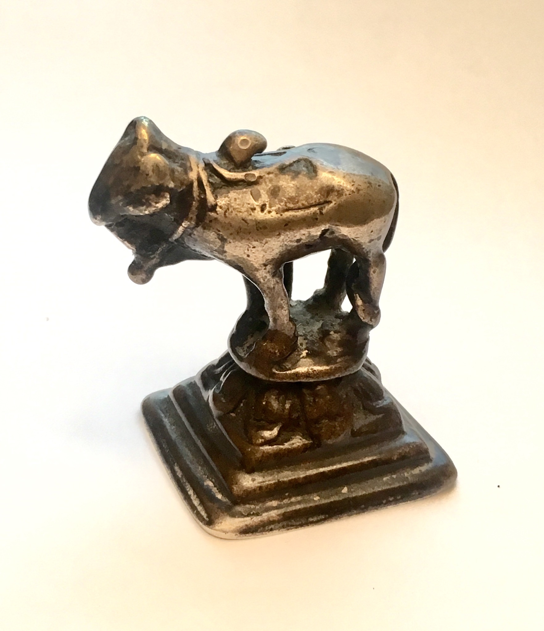 A Chamba model of a bull wearing a bell suspended from a necklace.